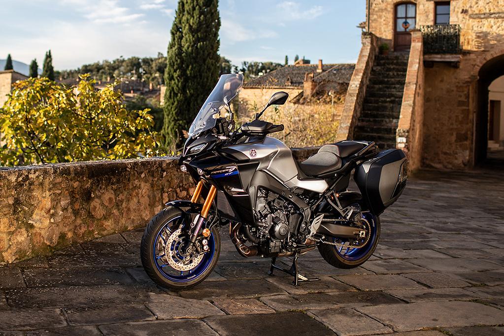 Yamaha Tracer 9 GT argent à l’arrêt dans une cour pavée